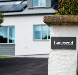 A house with solar panels and a sign labeled Lanesend at Lanesend in St Agnes