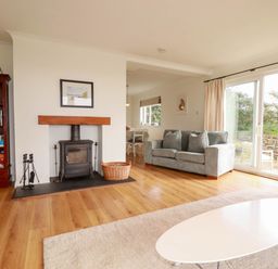 A living room with a fireplace and sofa at Seaport Lodge in Mawgan Porth