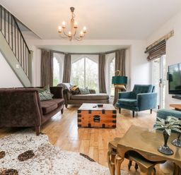 A living room with sofas a wooden chest coffee table a cowhide rug and a television at Lost Barn in Watergate Bay