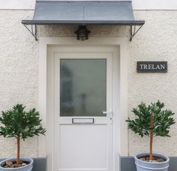 An entrance with a door and potted plants at Trelan in Mevagissey