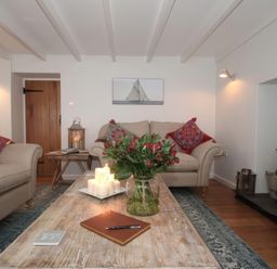 A living room with a sofa and table at Trelan in Mevagissey