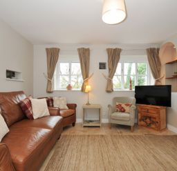 A living room with a sofa and television at Stocks Barn Looe