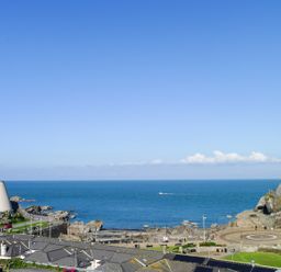 A coastal view with buildings, rocky shore, and the sea at 5 Arlington Villas in Ilfracombe