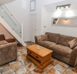 A living room with sofa and coffee table at Trelessy Lodge Llanteg near Amroth