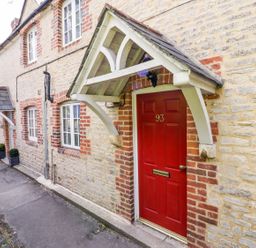 A stone exterior wall with a red door marked 93 and a small porch at Blenheim Edge The Causeway in Woodstock