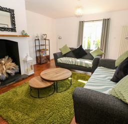 A living room with a sofa and coffee table at Blacksmiths Cottage in Shilbottle
