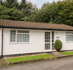 A single story house with tiled roof and windows with patterned curtains at Brook Haven Rosecraddoc Lodge near Liskeard Cornwall