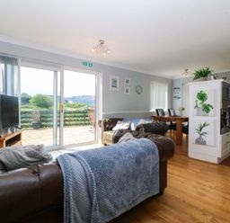 A living room with a sofa and television at Beach House (Ty Traeth) Deganwy