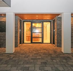 An entrance area with glass doors stone walls and tiled floor at Little Fistral in Fistral