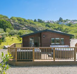 A cabin with a deck and hot tub at Costentyn, Tor Down Quarry in St Breward