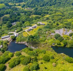 An aerial view of a landscape with water and buildings at Costentyn, Tor Down Quarry St Breward
