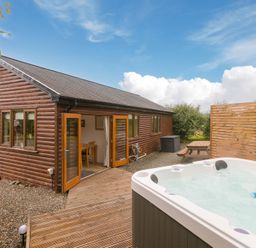 An outdoor area with a hot tub and seating at Tressa, Tor Down Quarry in St Breward