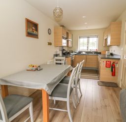 A kitchen and dining area with a table and chairs and wooden cabinets at 104 Sunrise Drive in Filey