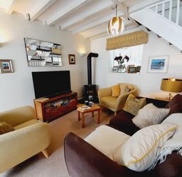 A living room with a television and sofa at Crab Cottage in Ilfracombe