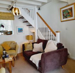 A living room with a stairway and furniture at Crab Cottage in Ilfracombe