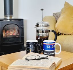A living room with a coffee table and mugs at Crab Cottage Ilfracombe