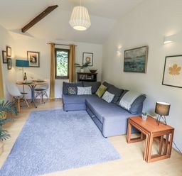 A living room with a sofa and dining area at Doe Foot Cottage Ingleton