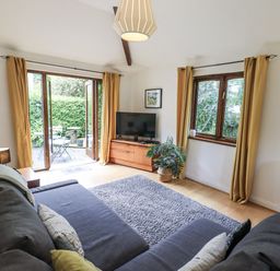 A living room with a sofa and television at Doe Foot Cottage Ingleton