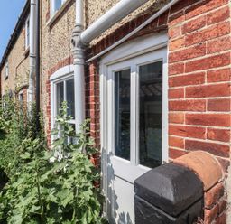 A door and window with surrounding plants at Delphinium in Blakeney, Norfolk