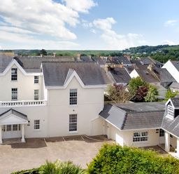 A group of houses with grey roofs and white walls under a blue sky at The Shell at the Hideaway in Tenby