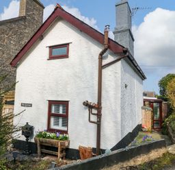 An outdoor view of a cottage with a garden and pathway at The Cottage Marian-Glas