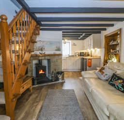 A living room with a staircase and a fireplace at The Cottage in Marian-Glas