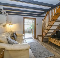 A living room with a sofa and stairs at The Cottage in Marian-Glas