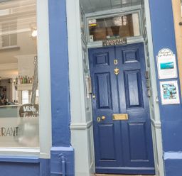 A blue door with the number 3 and restaurant signage outside a building at Apartment 2 Tenby