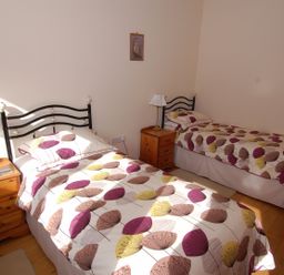 A bedroom with two single beds and wooden nightstands with lamps at The Milking Parlour in Wookey