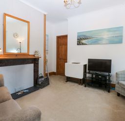 A living room with a television and seating area at 2 Argoed Llanbedrog