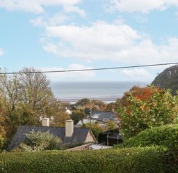 A view of the sea and surrounding houses at 2 Argoed Llanbedrog