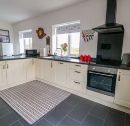 A kitchen with cabinets, sink, and appliances at Hafod Wen in Pentraeth