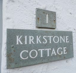 Signs on a wall displaying number 1 and Kirkstone Cottage
