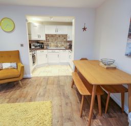 A dining room with a table and chairs at Y Enciliad Rhosneigr