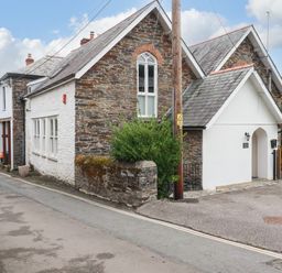 A house with a stone exterior and windows at Tower House in Boscastle