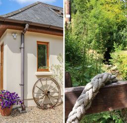 An exterior corner of a house with flower pots and a wooden wheel and a close-up of a rope on a wooden railing with green plants in the background at Cross Syke Barn in Loxhore near Barnstaple