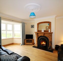 A living room with a fireplace a television and leather sofas at Benbulben View in Tullaghan County Leitrim