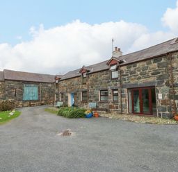 An outdoor area with stone buildings and benches at Hafod Y Felinheli