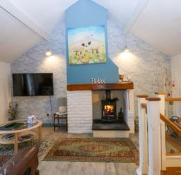 A living room with a fireplace and television at Hafod in Y Felinheli