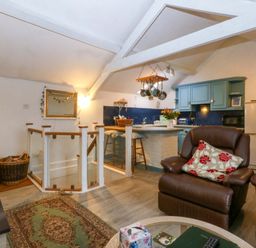 A living room with a kitchen area and seating at Hafod in Y Felinheli