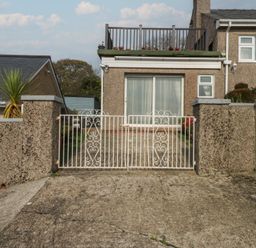 An outdoor area with a gate and a house front at Maesawel Studio in Llanfair