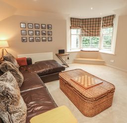 A living room with a sofa and checkers board at Kelsick Heights in Ambleside