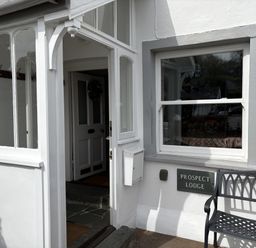 An entrance with a door and a bench at Prospect Lodge in Portinscale