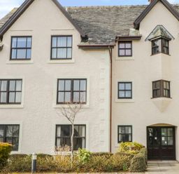 Exterior of a multi windowed residential building with shrubs and small trees at Andra Ghyll in Keswick