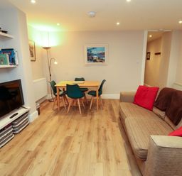 A living room with a sofa and dining area at Archers in Keswick