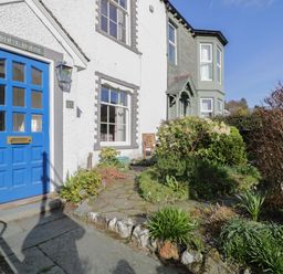 The front entrance of a house with a blue door and surrounding garden at White House in Keswick