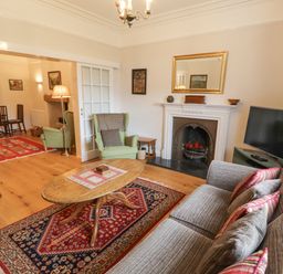 A living room with a sofa table lamp armchair and fireplace at White House in Keswick