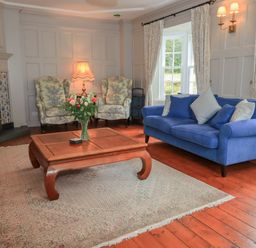 A living room with armchairs, a sofa, and a coffee table at Little Ellers Portinscale near Keswick