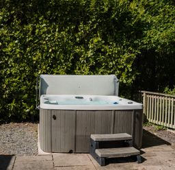A hot tub with steps beside a fence at The Snug in Longtown