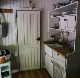 A kitchen with a sink and storage at The Snug in Longtown